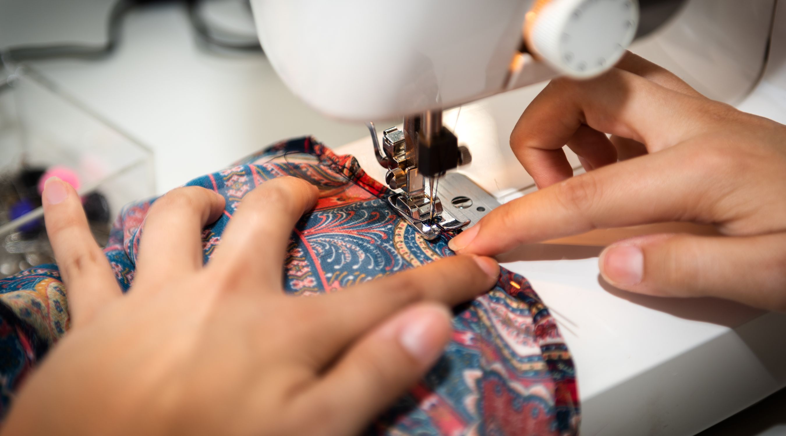 Cours de couture à la MJC de Gex, guidage d'un tissu à motifs sous l'aiguille d'une machine à coudre