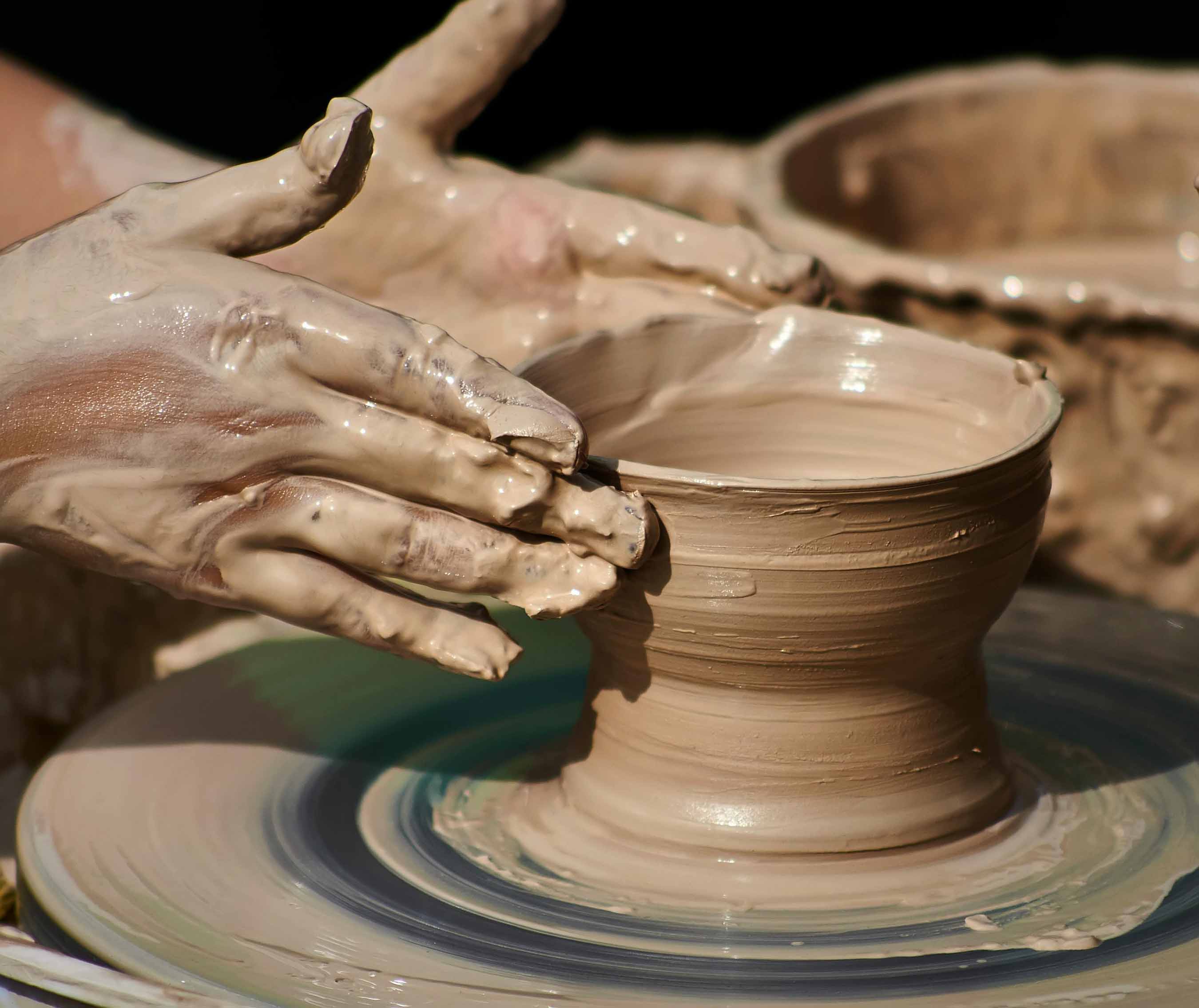 Atelier poterie à la MJC de Gex, mains façonnant un bol en argile humide