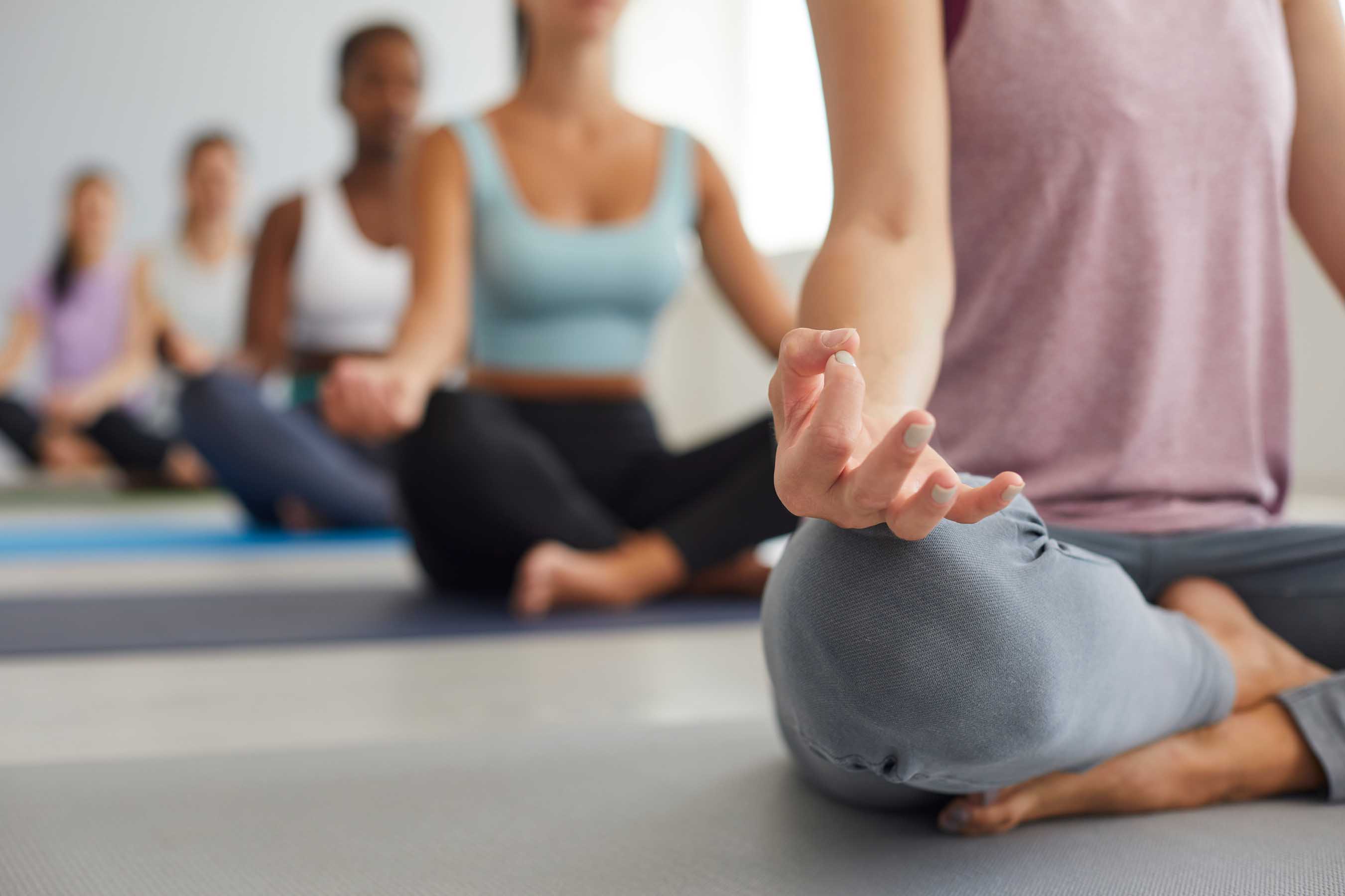 Séance de méditation et bien-être à la MJC de Gex, femme avec les yeux fermés et les mains jointes en pleine relaxation