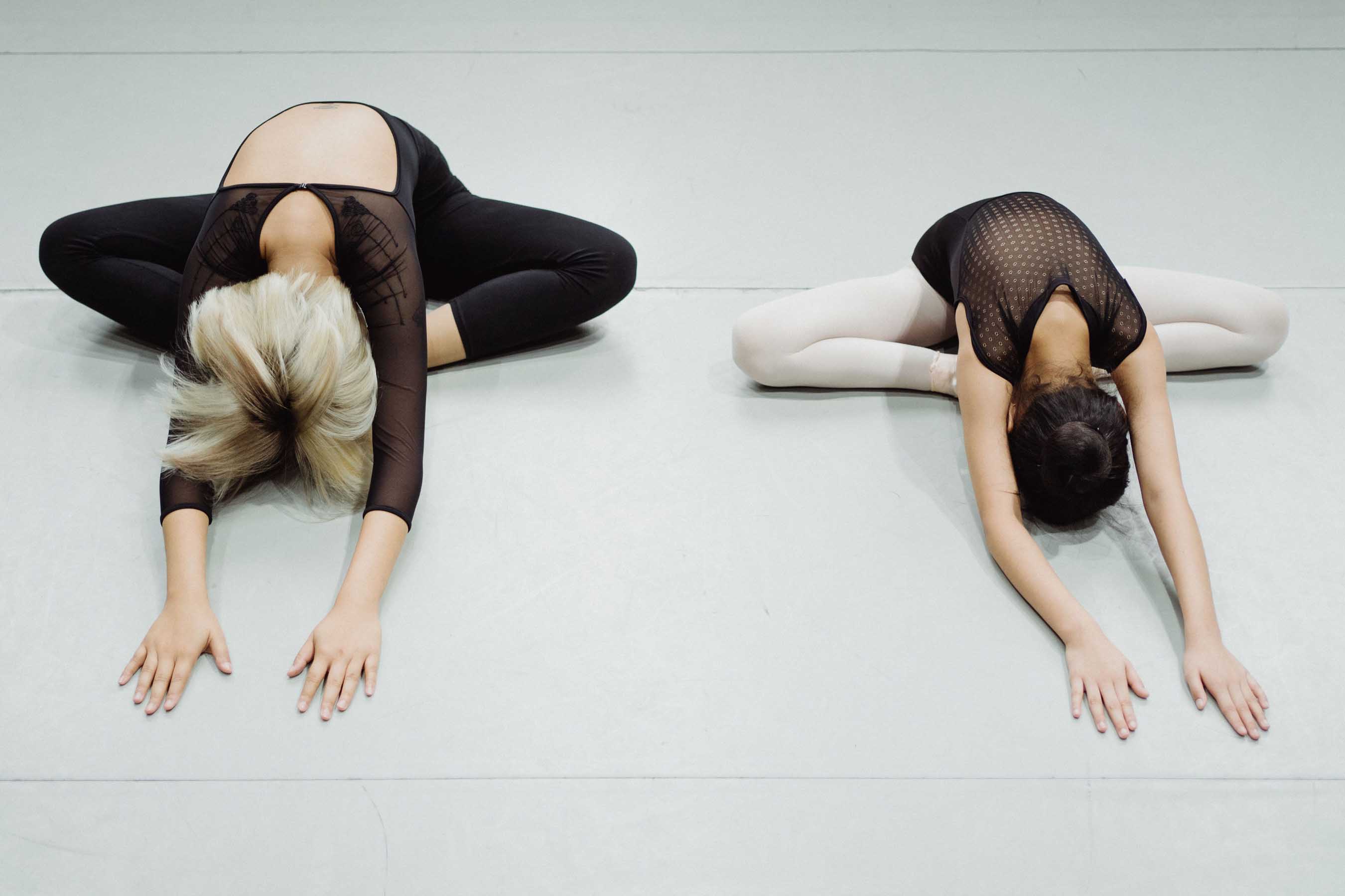 Cours de barre à terre à la MJC de Gex, femme en tenue claire effectuant un exercice d'assouplissement et de posture au sol