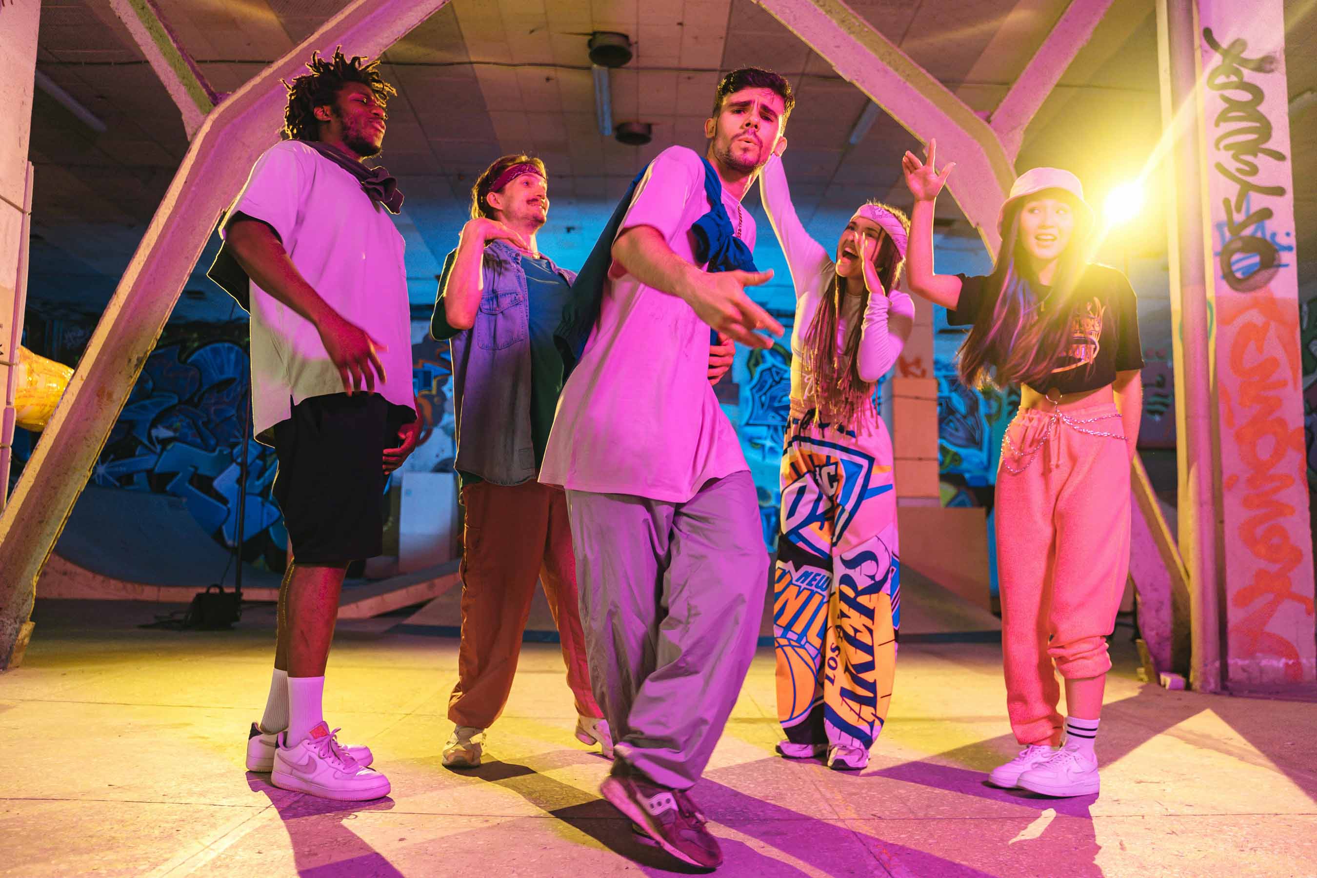 Activité hip-hop et street dance, groupe de danseurs urbains en pleine démonstration dans un décor de skatepark sous des lumières néon